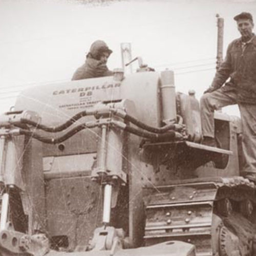 Veit Crew Standing On CAT Bulldozer In 1920s