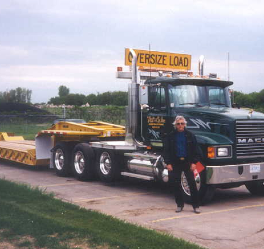 Old Photo Of Vaughn Veit Standing In Front Of Oversized Loader Truck