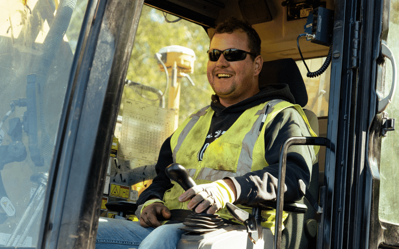 Man smiling while operating heavy equipment