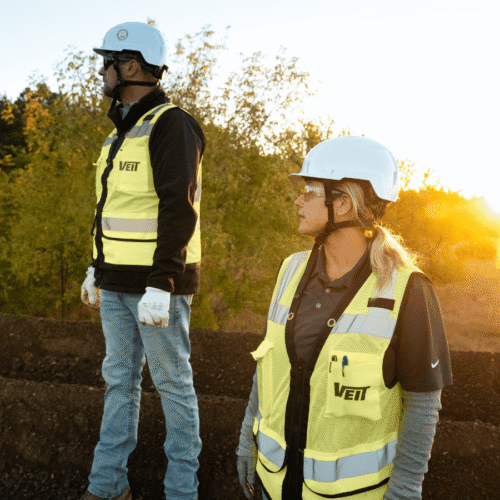 Two Veit employees looking to their right at sunrise